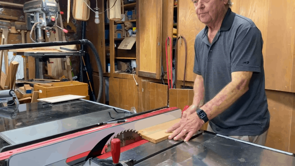 Man carefully cutting wood using a table saw