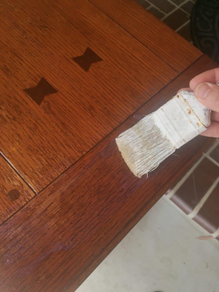 Using a brush to apply varnish on a piece of wood