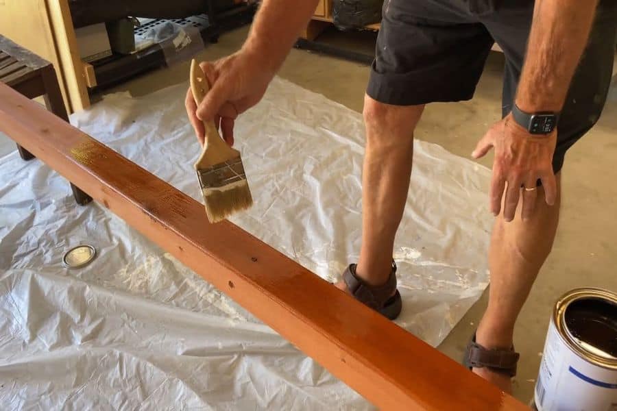 Man applying varnish on a piece of wood