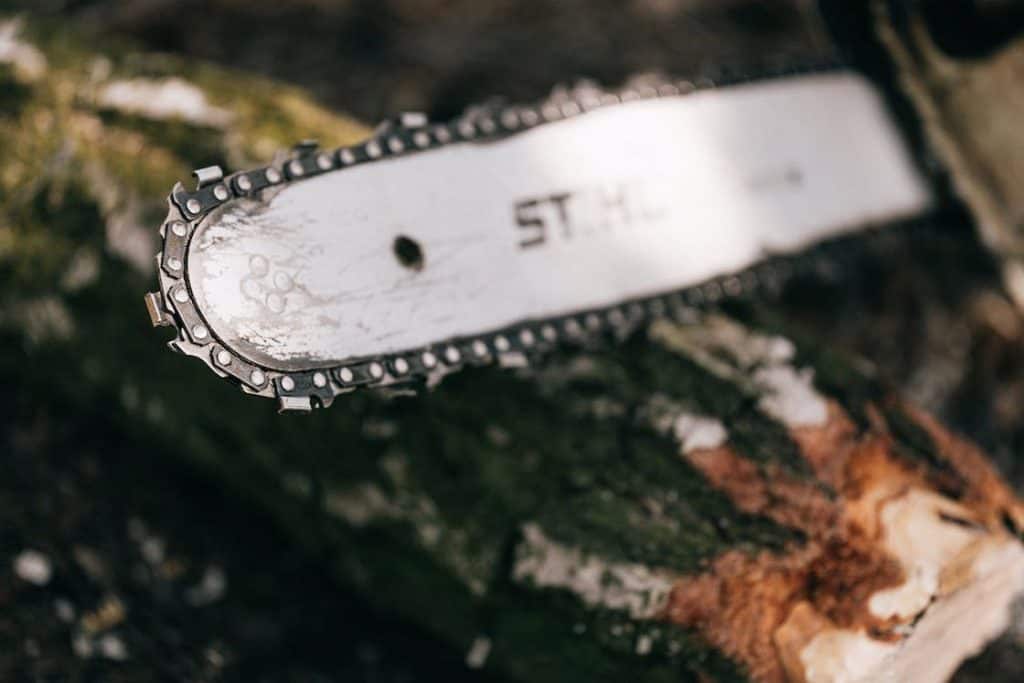 Close up of a Stihl chainsaw resting on a log