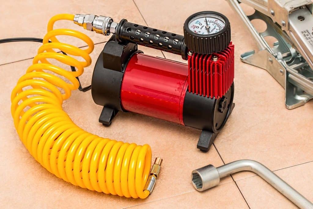 Red portable air compressor placed on the tiled floor