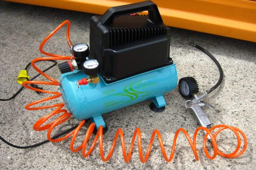 Blue small air compressor placed on the ground outdoors
